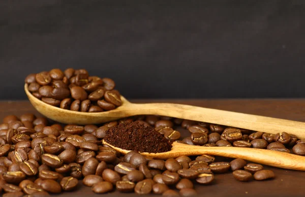 Coffee beans and ground coffee on wooden spoon with grunge backg — Stock Photo, Image