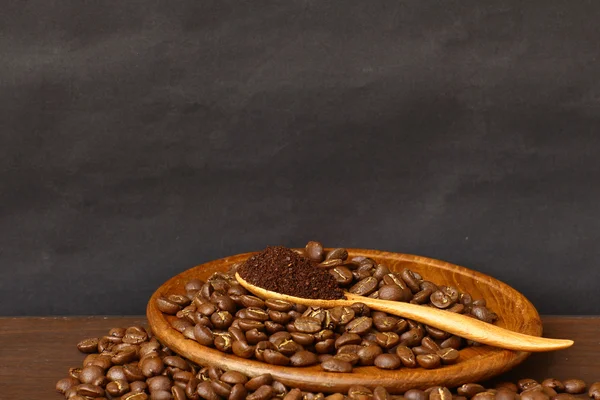 Coffee beans and ground coffee on wooden spoon with grunge backg — Stock Photo, Image