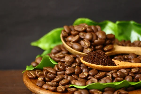 Chicchi di caffè e caffè macinati su cucchiaio di legno — Foto Stock