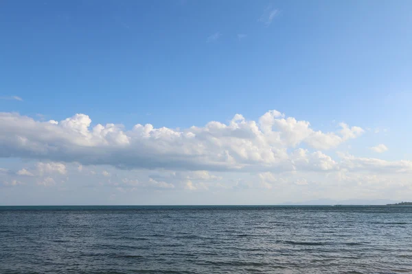 Panoramic seascape with puffy white clouds, blue sky and green oc — стоковое фото