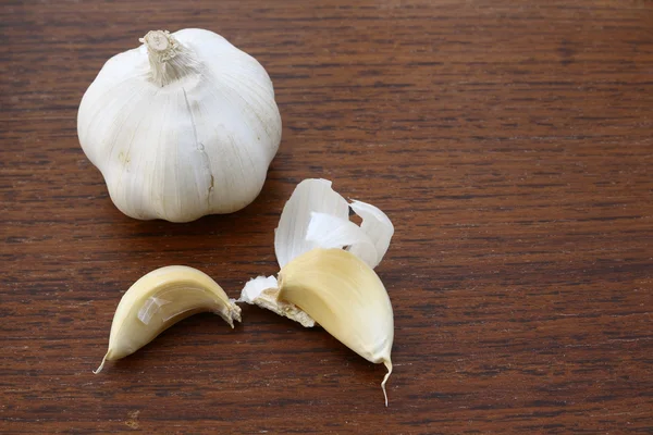 Garlic on grunge chopping board — Stock Photo, Image