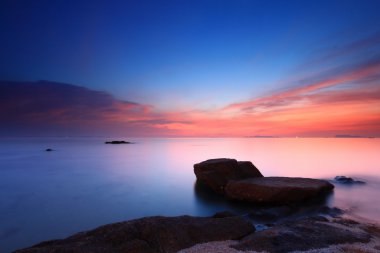 Seascape zachód słońca z fantastycznym rock powierzchni i czerwone niebo, długo ex