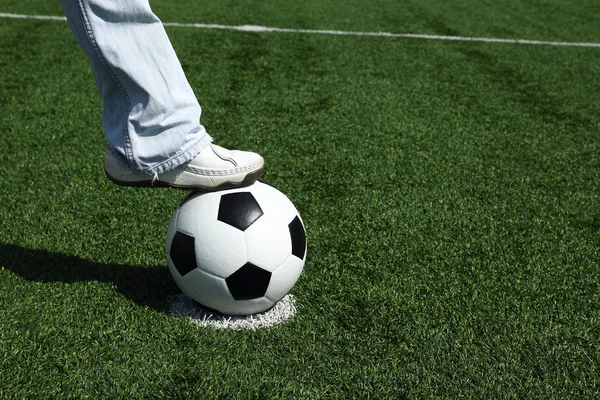 Casual guy in blue jeans stepping onto a soccer ball in outdoor — Stock Photo, Image