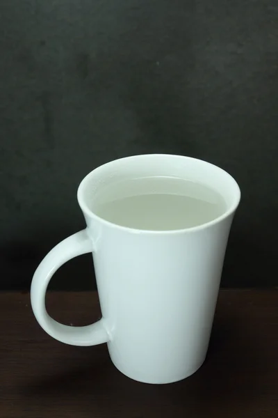 Keramik weiße Tasse Wasser auf Holztisch — Stockfoto