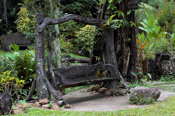 Старые деревянные качели в зеленом саду
