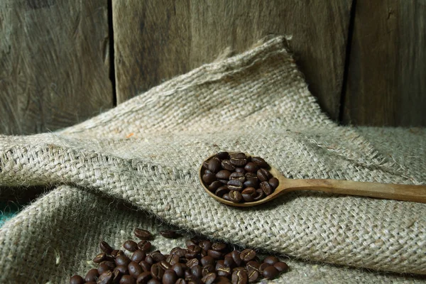 Grains de café en cuillère en bois sur sac — Photo