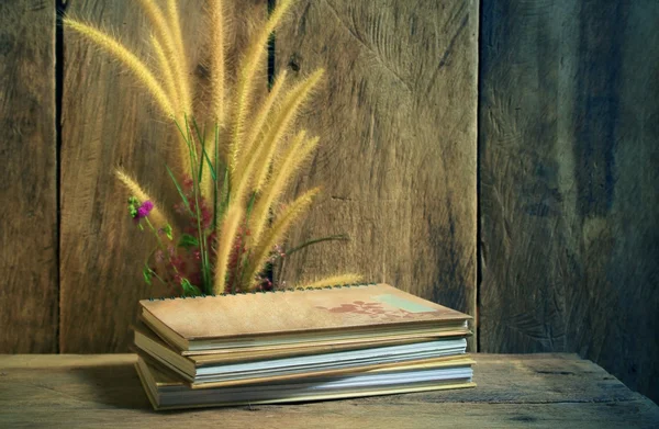 Still life with notebooks and flower foxtail weed in golden light on wooden background — Stock Photo, Image