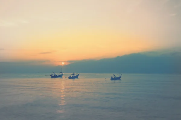 Menakjubkan matahari terbenam emas di atas laut dan langit dengan perahu nelayan mengambang — Stok Foto