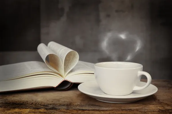 Натюрморт с чашкой кофе и книга на гранж деревянный стол в винтажном стиле — стоковое фото