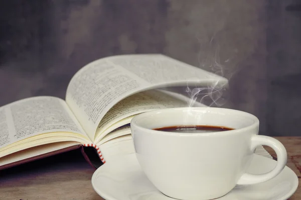 Still life with cup of coffee and book on grunge wood table in vintage style — Stock Photo, Image