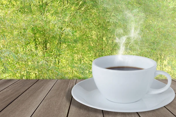 Kopp kaffe på trägolv med bambu staket — Stockfoto