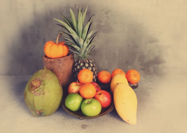 Bodegón de manzana, piña, calabaza, coco, mandarina y mango sobre mesa de madera en estilo vintage —  Fotos de Stock