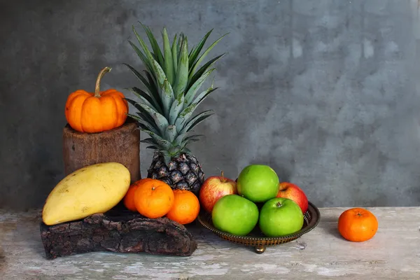 Bodegón manzana, piña, mandarina de calabaza y mango sobre mesa de madera —  Fotos de Stock