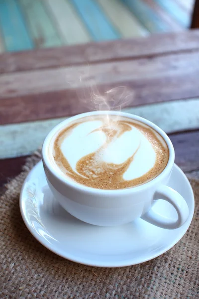 Gelas seni latte hati di meja kayu grunge — Stok Foto