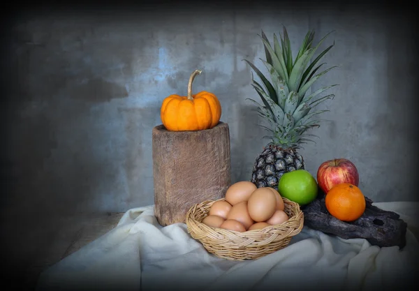 Натюрморт яблоко, ананас, омлет и корзина с яйцами в винтажном стиле — стоковое фото