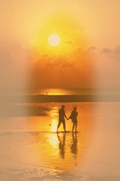 Sílhuetas de praia de pessoas relaxando ao pôr do sol — Fotografia de Stock