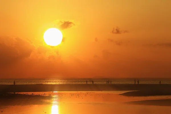 Silhouettes de plage de personnes se relaxant au coucher du soleil — Photo