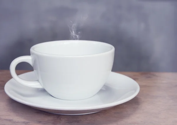 ถ้วยกาแฟบนโต๊ะไม้กรังจ์ในสไตล์วินเทจ — ภาพถ่ายสต็อก