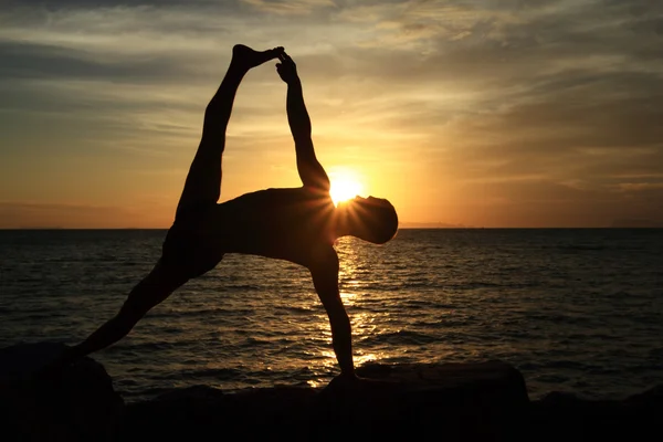 Man act yoga on rock