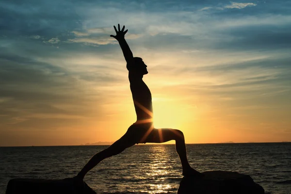 Człowiek działa jogi na skale — Zdjęcie stockowe