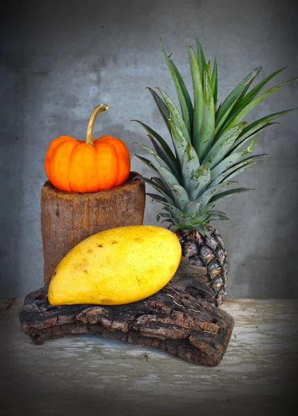 Stilleben pumpa, ananas och mango frukt antika trä ombord — Stockfoto