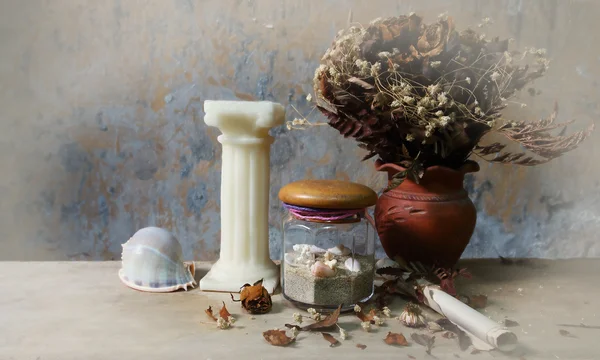キャンドル、貝殻、乾燥したバラ、木製テーブルにグランジ紙のある静物 — ストック写真