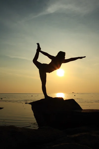 Silueta yoga chica por la playa al amanecer haciendo Señor de la Baile Pose — Foto de Stock