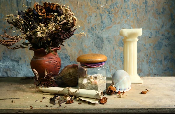 キャンドル、貝殻、乾燥したバラ、木製テーブルにグランジ紙のある静物 — ストック写真