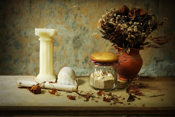 Still life with candle, seashell,dry roses and grunge paper on wooden table — Stock Photo, Image