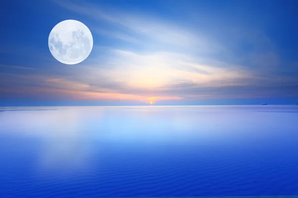 Surrealistische volle maan over sunsrise blauwe zee en hemel — Stockfoto