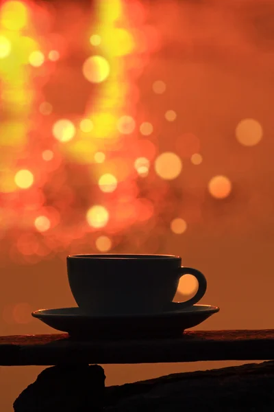 Ochtend koffie beker op een houten bord met bokeh achtergrond — Stockfoto