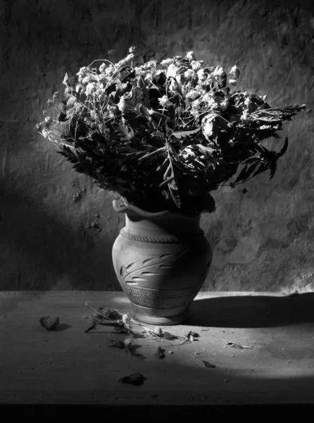Natureza morta com buquê preto e branco de rosas secas em barro — Fotografia de Stock