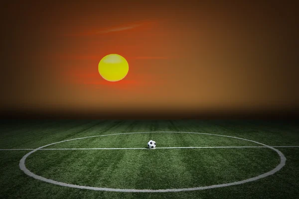 Voetbal groen grasveld bij zonsondergang — Stockfoto