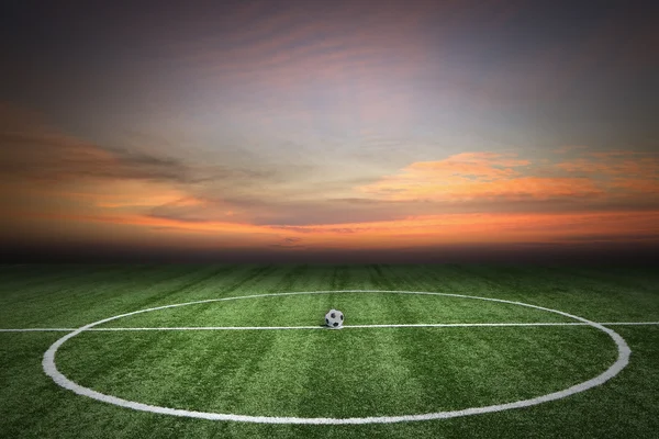 Voetbal groen grasveld bij zonsondergang — Stockfoto