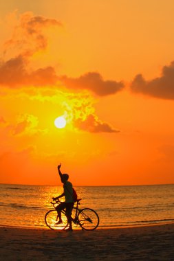 Sunset beach noktasında bir bisikletçinin silüeti