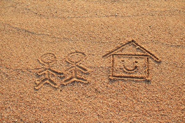 Glücklicher Liebhaber und Haus mit Lächeln-Symbol auf Sand am Strand gezeichnet — Stockfoto
