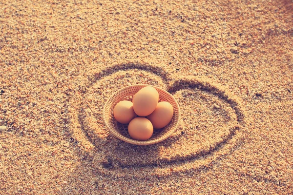 Ovos de Páscoa em cesta de bambu na praia — Fotografia de Stock