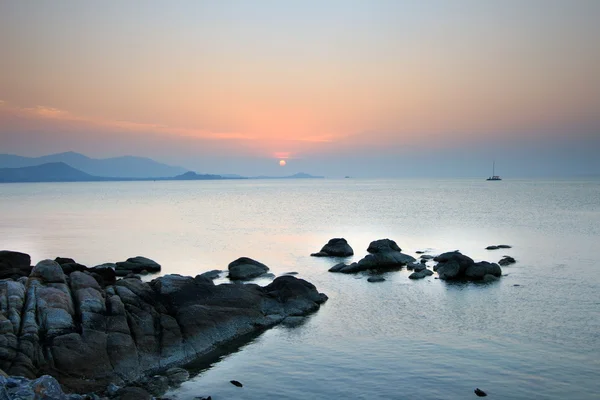 Roca en la playa con puesta de sol — Foto de Stock