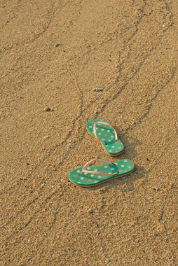 kum üzerinde renkli flip flop