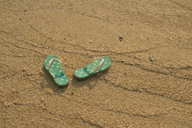 kum üzerinde renkli flip flop