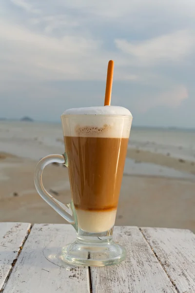 Kop warme koffie met zee achtergrond — Stockfoto