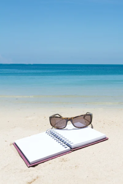 Beach summer time,book sunglass on white sand beach — Stock Photo, Image