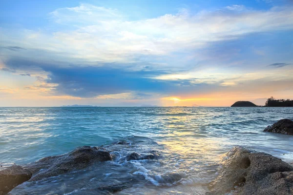 Panorâmica dramática tropical por do sol céu e mar com superfície de rocha — Fotografia de Stock