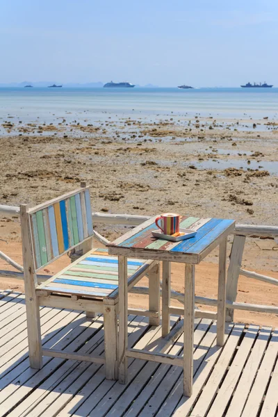 Coffee cup on terrace facing seascape — Stock Photo, Image