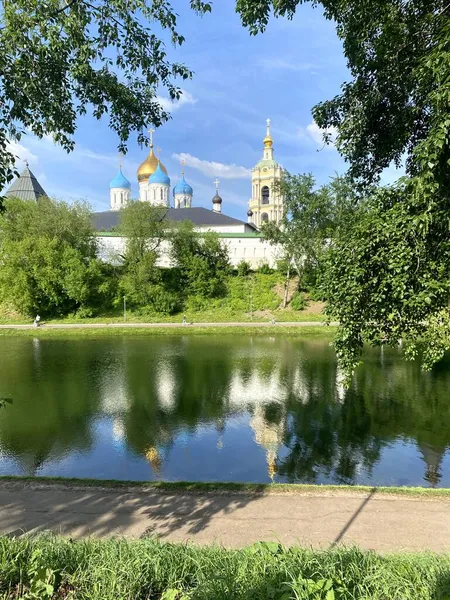 Güneşli bir yaz gününde Novospassky Stavropol Manastırı 'nın panoramik manzarası. Manastır göletinin sularındaki manastırın yansıması.