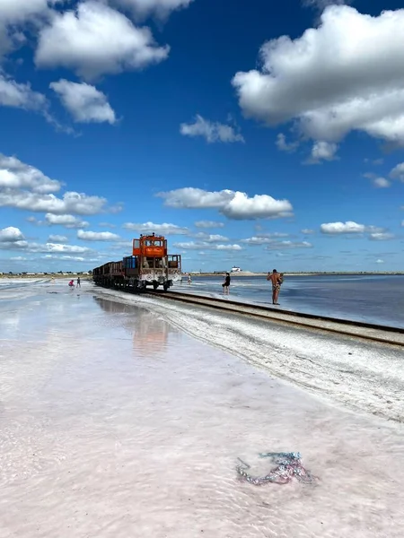 列車は青い空に向かって水の上に浮かんでいる 塩鉱業 ロシアのアルタイのブルソル湖 ストックフォト