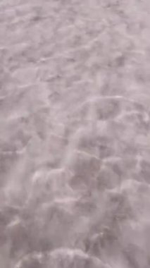 Tuzlu göl, güzel bulutlar, güneş, ufukta tren, suda yansımalar ve ön planda raylar. Bursol Gölü, Altai, Rusya.