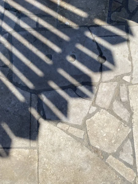 gray paving slabs, shadows on the footpath, shadow on the city path during the day. Old city, Egypt, March 2022: Naama Bay in Sharm El Sheikh, Egypt.