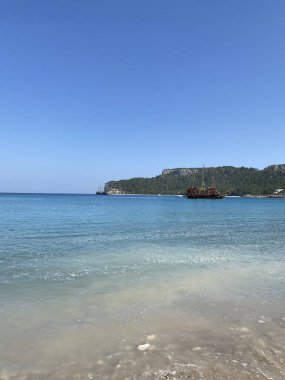 Sahilde deniz ve dağlar. Kemer, Antalya, Türkiye. Türkiye 'deki en iyi tatil kavramı. Boş sahilden kayalara ve ufka bak. Akdeniz.