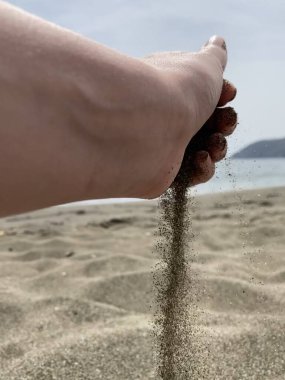 Siyah kum tutan kadın eller. Elle kumsal patlaması